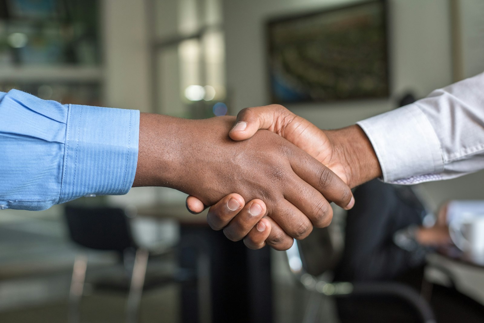 Advocate and client shaking hands in a meeting room
